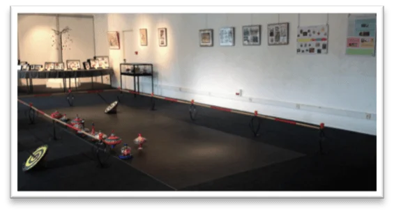 Toupidrome, arène géante où les visiteurs peuvent lancer des toupies mexicaines ou faire tourner des toupies à manivelles, en origami pendant l'exposition-animation Le Bal des Toupies, création de Tous en Jeu